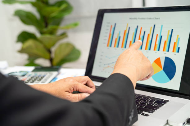 istock Asian accountant working and analyzing financial reports project accounting with chart graph in modern office, finance and business concept. 1574245904