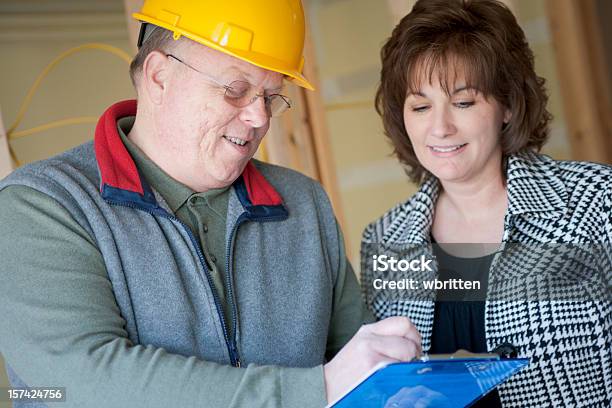 Architect Showing Woman Blue Prints Of His Work Stock Photo - Download Image Now - Building Contractor, Customer, Adult