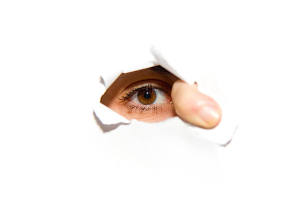 istock An eye looking through a hole in the wall 157424880