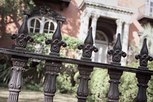 Iron fence surrounds a Victorian home.