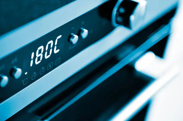 Close-up of modern oven, baking temperature, kitchen interior, blue toned.