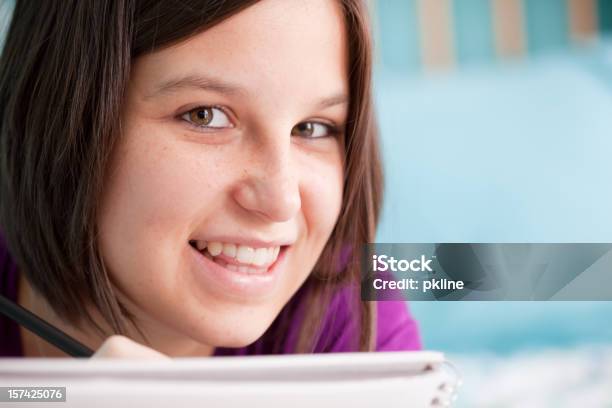 Adolescente Sonriente Escribiendo En Su Cama Foto de stock y más banco de imágenes de Acogedor - Acogedor, Adolescencia, Adolescente