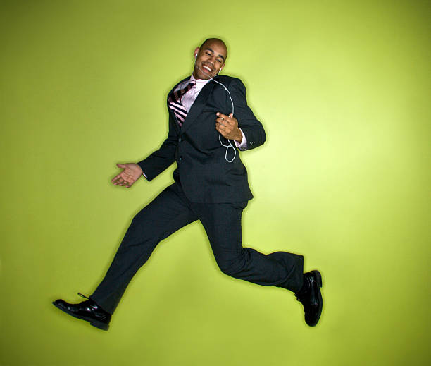 Man in suit jumping to music stock photo