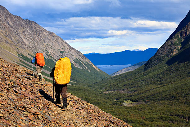 Down the Trail Two backpackers on the trial high in the Fuegian Andes of Tierra del Fuego, Argentina. The Beagle Channel is visible in the background. tierra del fuego archipelago stock pictures, royalty-free photos & images