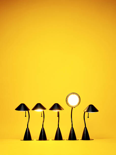 Bright Idea, Five desk lamps against yellow stock photo