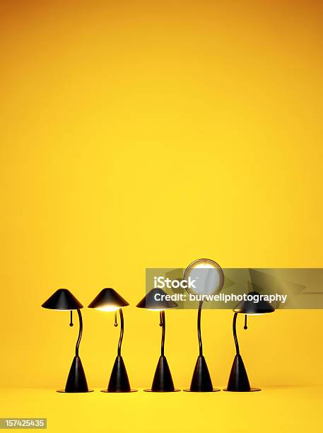 Bright Idea Five Desk Lamps Against Yellow Stock Photo - Download Image Now - Standing Out From The Crowd, Individuality, Electric Lamp
