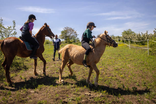 istock Girls training riding horses 1574258334