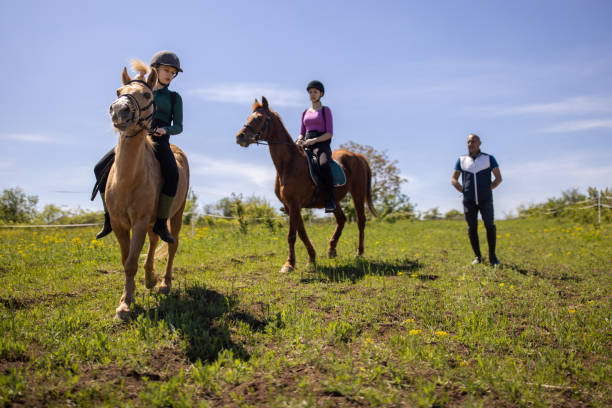 istock Girls training riding horses 1574258896