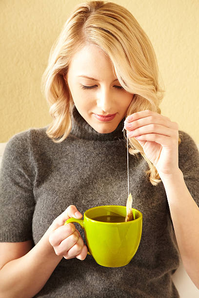 kobieta pije herbata zielona w domu - green tea tea teabag green zdjęcia i obrazy z banku zdjęć