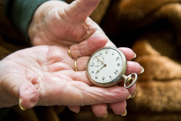 istock Old hands holding a silver pocket watch 157427157