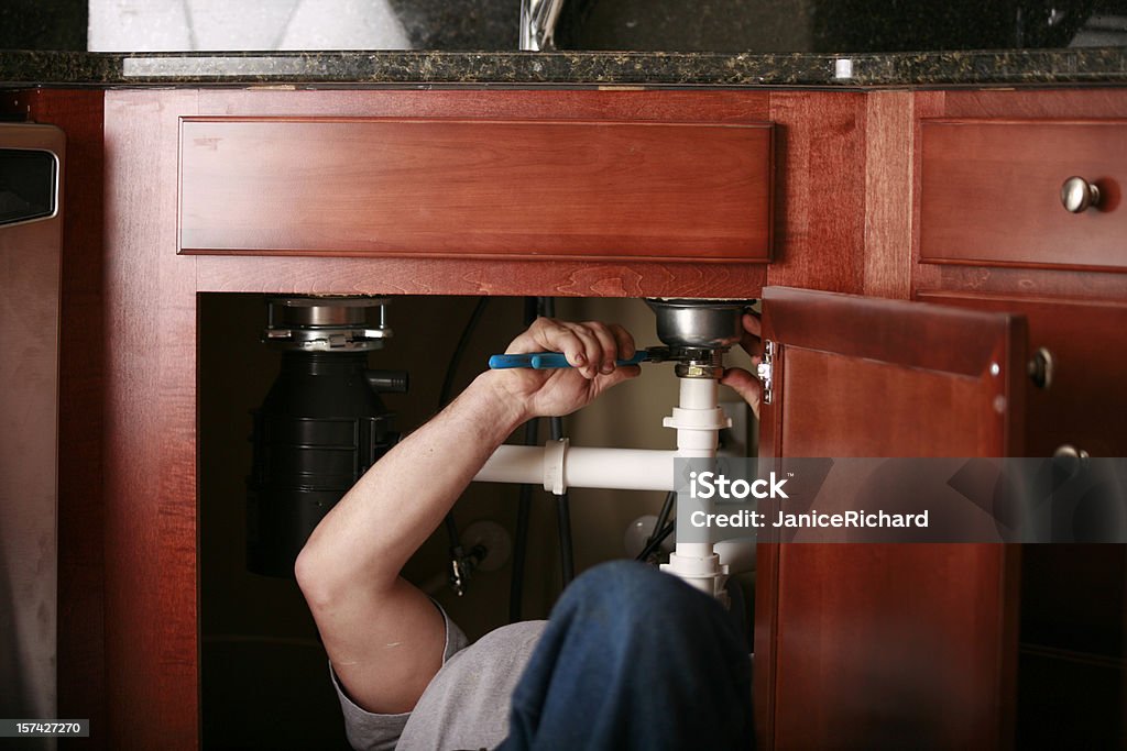 Profesional de fontanero instalar un lavamanos de la cocina - Foto de stock de Gestión de residuos libre de derechos