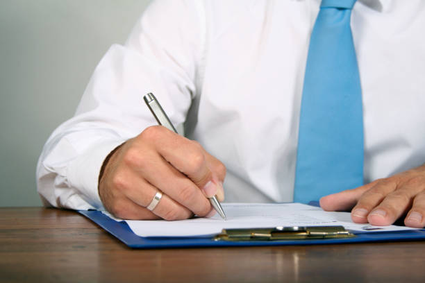 istock businessman fillin out papers 157427683