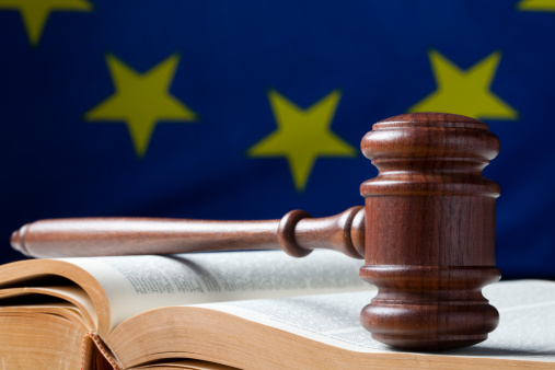 Gavel on bible and EU flag in the background.