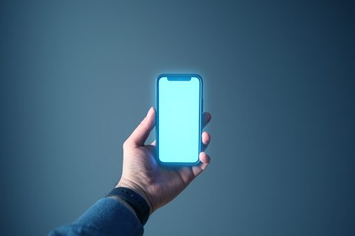Hand holding a smartphone with a blue shiny screen