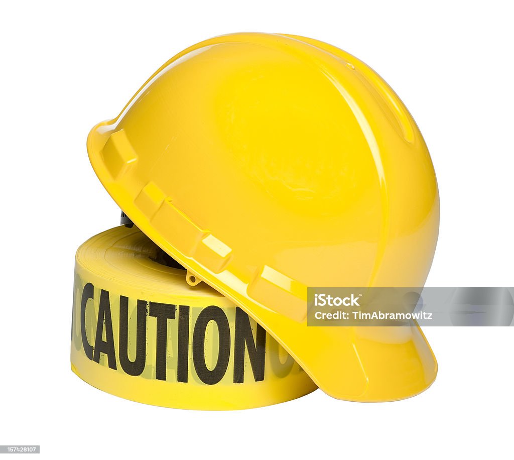 Hard Hat and Caution Tape Yellow hard hat leaning on work area caution tape. Hardhat Stock Photo