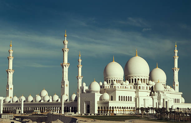 A beautiful white mosque on a partly cloudy day stock photo