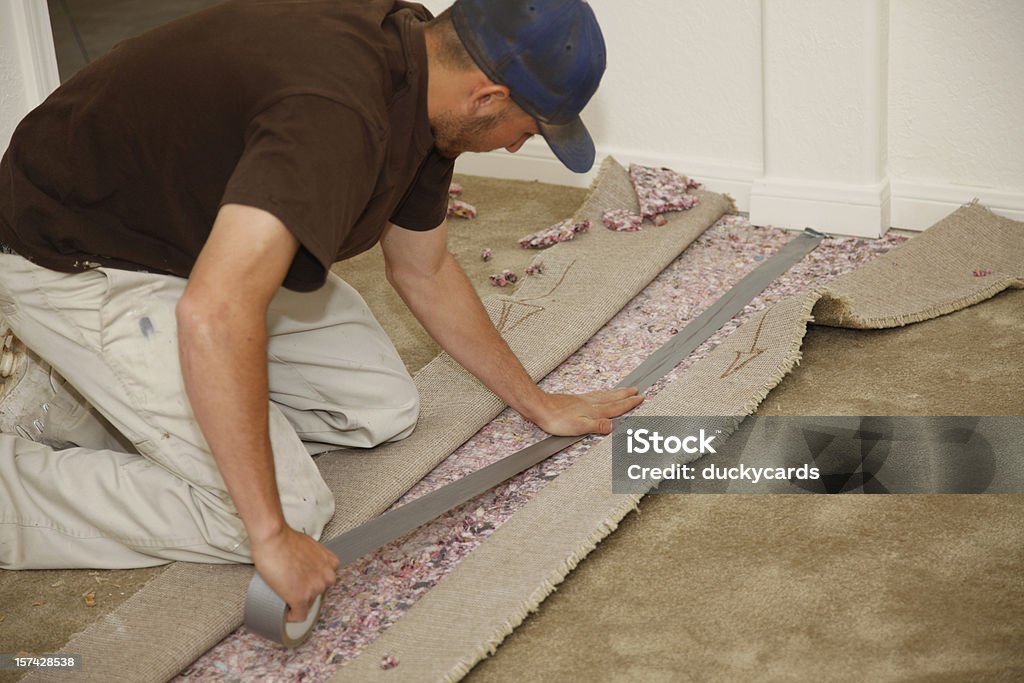 Homme installation de nouveaux tapis - Photo de Ruban chatterton libre de droits