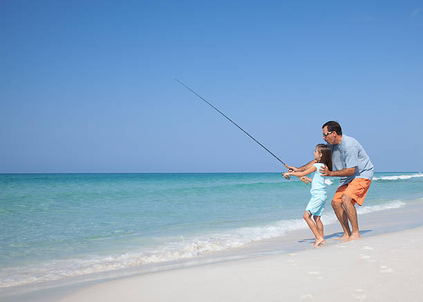Father and Daughter Surf Fishing  sea fishing stock pictures, royalty-free photos & images