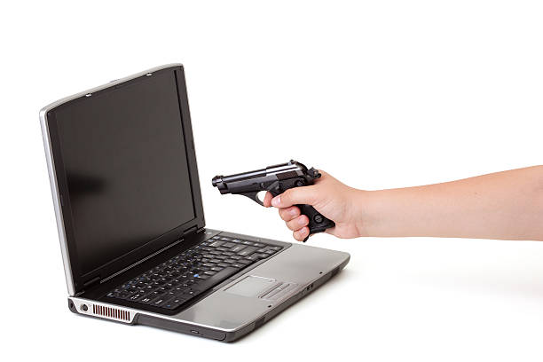 arme à feu pointée, à un ordinateur portable - computer shooting handgun gun photos et images de collection