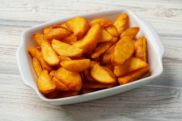 istock Fried potato wedges in white ceramic bowl 1574291163