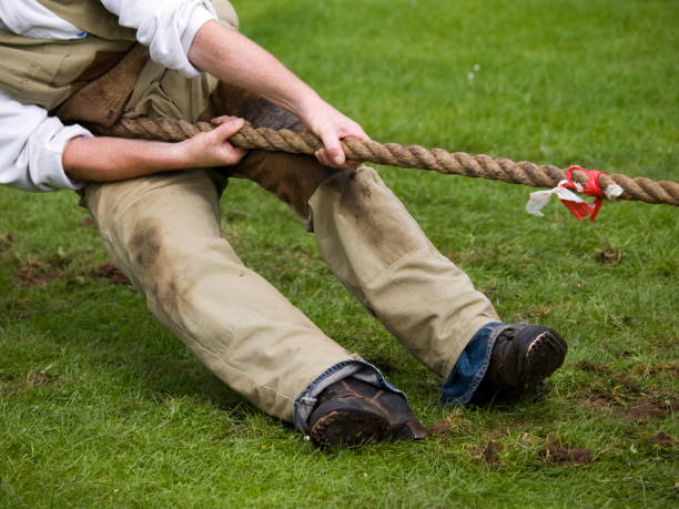 istock Midsection view of a man pulling a rope in a tug-of-war. 157429303