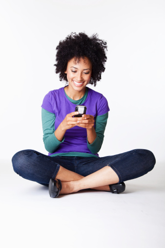 Bastante Joven mujer sentada con las piernas cruzadas sonriendo SMS photo