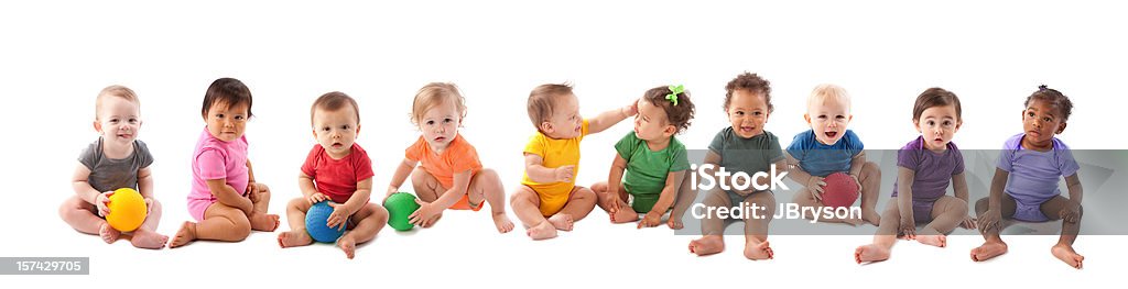 Diverse group of ten babies playing An image of babies and toddlers of various ethnicities wearing colorful onesies and sitting side by side in a long line. Baby - Human Age Stock Photo