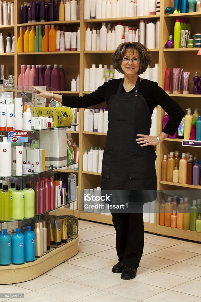 Mulher de beleza cabelo em pé com venda de produtos - Foto de stock de Avental royalty-free
