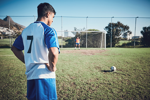 Soccer, game and a man on a field for a goal, sports penalty or training for a team. Fitness, focus and an athlete getting ready to kick a football during a competition for cardio, win or playing