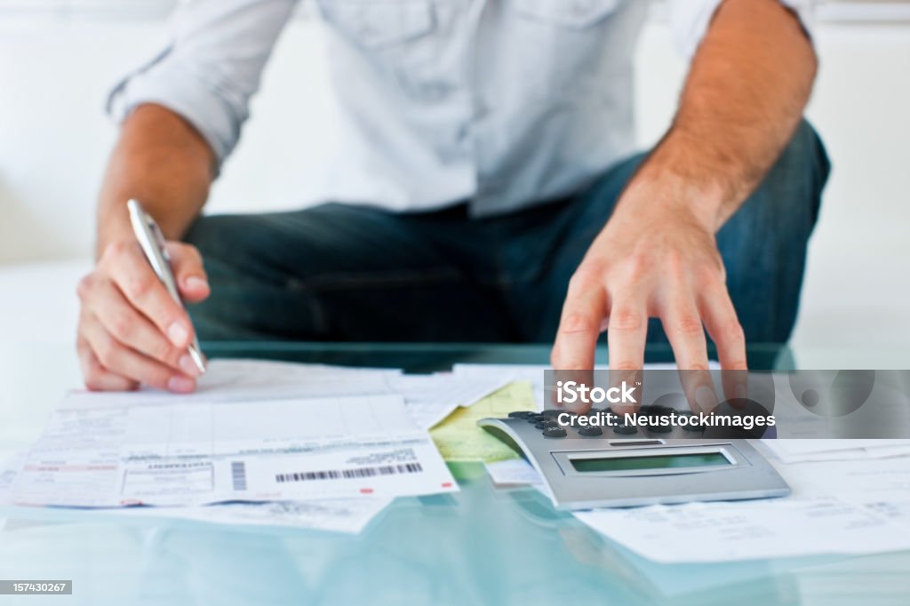 Cropped image d'homme assis avec calculateur - Photo de Finances personnelles libre de droits