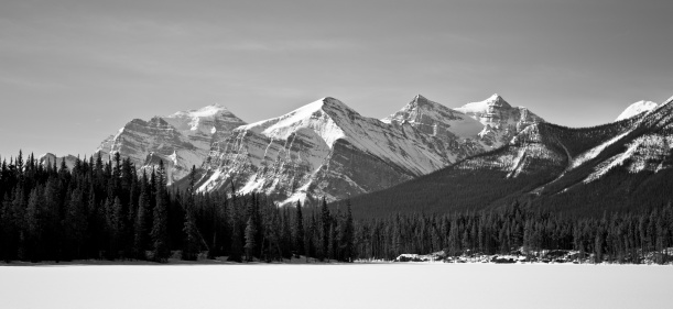 Canadian Rockies with frozen lake and snowcapped peaks, Alberta.