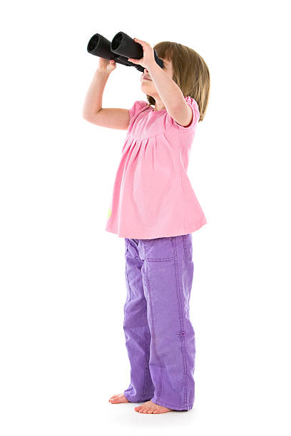 Little cute girl holding on to handrail in summer park. Concept of happy active child outdoors
