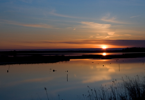A beautiful sunset at the Blackwater National Wildlife Refuge in Cambridge, Maryland.  Just a slight ripple in the water in the foreground.