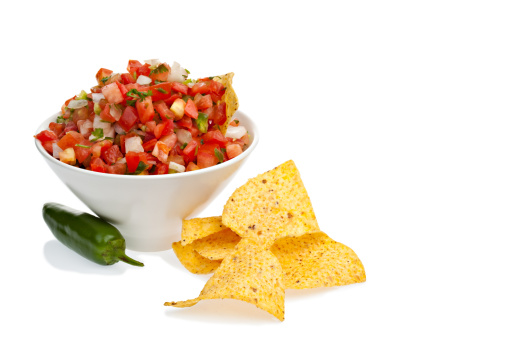 A bowl of Pico de gallo salsa and chips on a white background.