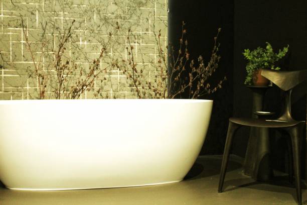 istock White bathtub in stylish bathroom scandinavian interior design with elegant accessories. Modern bright loft eco style bathroom, freestanding bath. Cozy retro-chic interior with art deco bathroom 1574323510