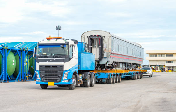 istock Transport of Oversize Heavy cargo trailera new passenger train on a multi-axle hydraulic modular truck trailer Loading a port area 1574326474