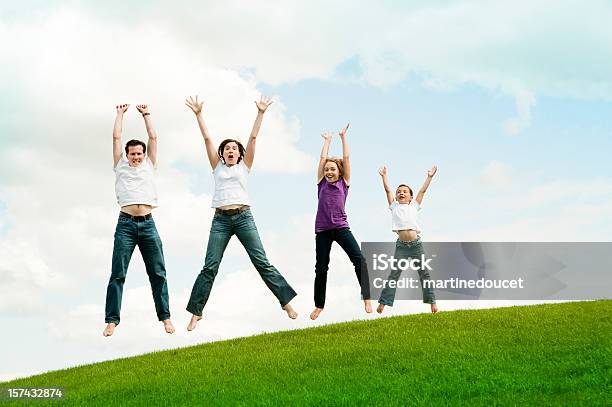 Foto de Família Feliz De Quatro Pulando Na Terra Comprimento e mais fotos de stock de Adulto