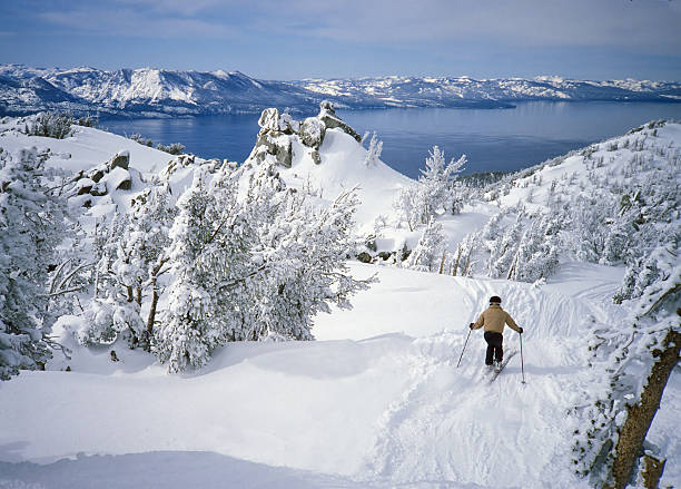 Skier in Fresh Snow Above Alpine Lake Tahoe stock photo