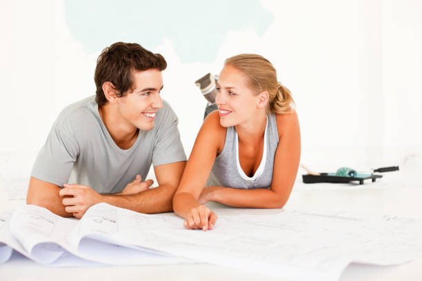 istock Young couple working on plans for their unfinished home 157433079
