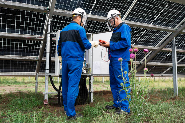 dwóch inżynierów serwisu lub elektryk pracuje nad sprawdzeniem lokalizacji transformatora i rozwiązaniem problemu pracy zielonej elektrowni słonecznej. techniczny konserwator ogniw słonecznych w elektrowni słonecznej - procession panel zdjęcia i obrazy z banku zdjęć