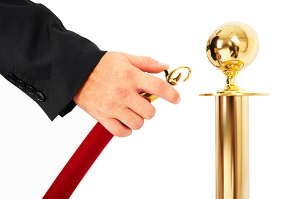 Human hand unlocking a queue barrier on white  roped off stock pictures, royalty-free photos & images