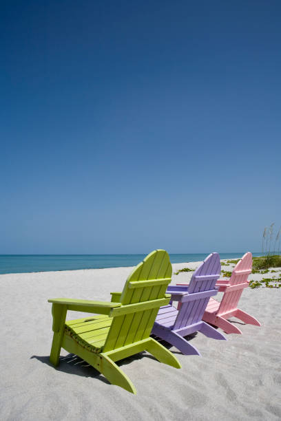 istock Three pastel colored beach chairs on sand at beach 157433180