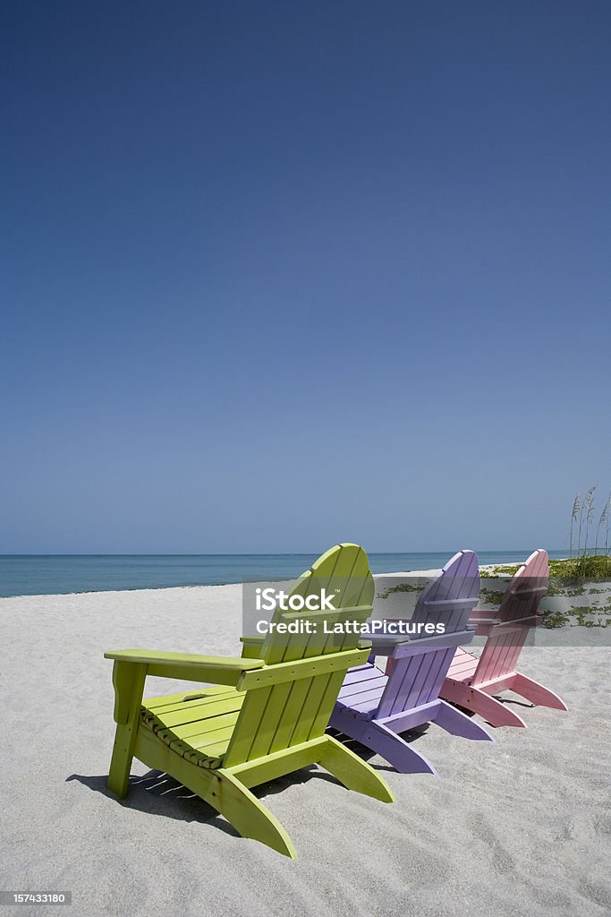 Trzy Pastelowy kolor plaży krzesła na piasku na plaży - Zbiór zdjęć royalty-free (Fotel)