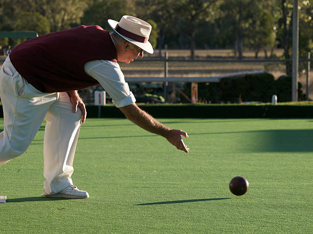 Man lawn bowling on sunny day 