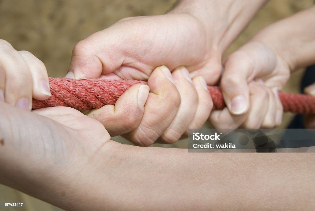 Travail d'équipe les mains pour la corde - Photo de Tir à la corde libre de droits