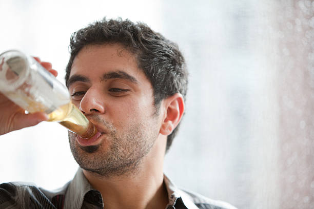istock Young man drink beer from the bottle 157433494
