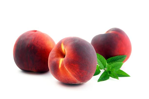 Three Ripe Peaches and Mint Leaves stock photo