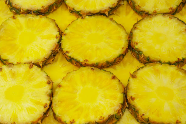 istock Pineapple juicy yellow slices as a background. 1574335881