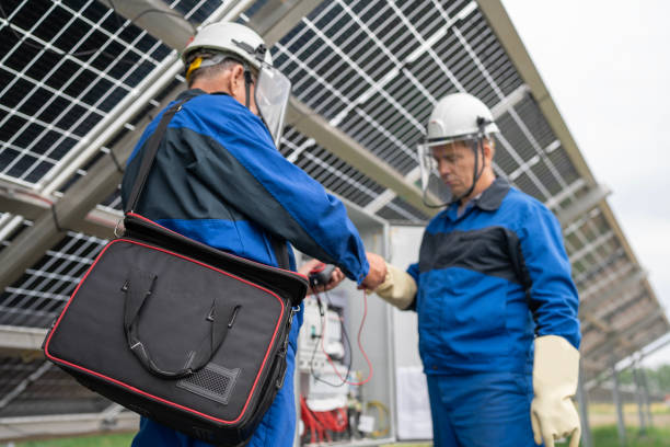 dwóch inżynierów serwisu lub elektryk pracuje nad sprawdzeniem lokalizacji transformatora i rozwiązaniem problemu pracy zielonej elektrowni słonecznej. techniczny konserwator ogniw słonecznych w elektrowni słonecznej - procession panel zdjęcia i obrazy z banku zdjęć