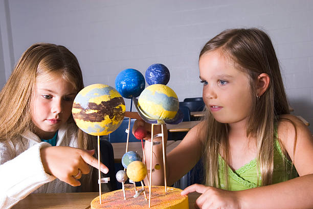 istock Girls working with space models in the classroom 157434551